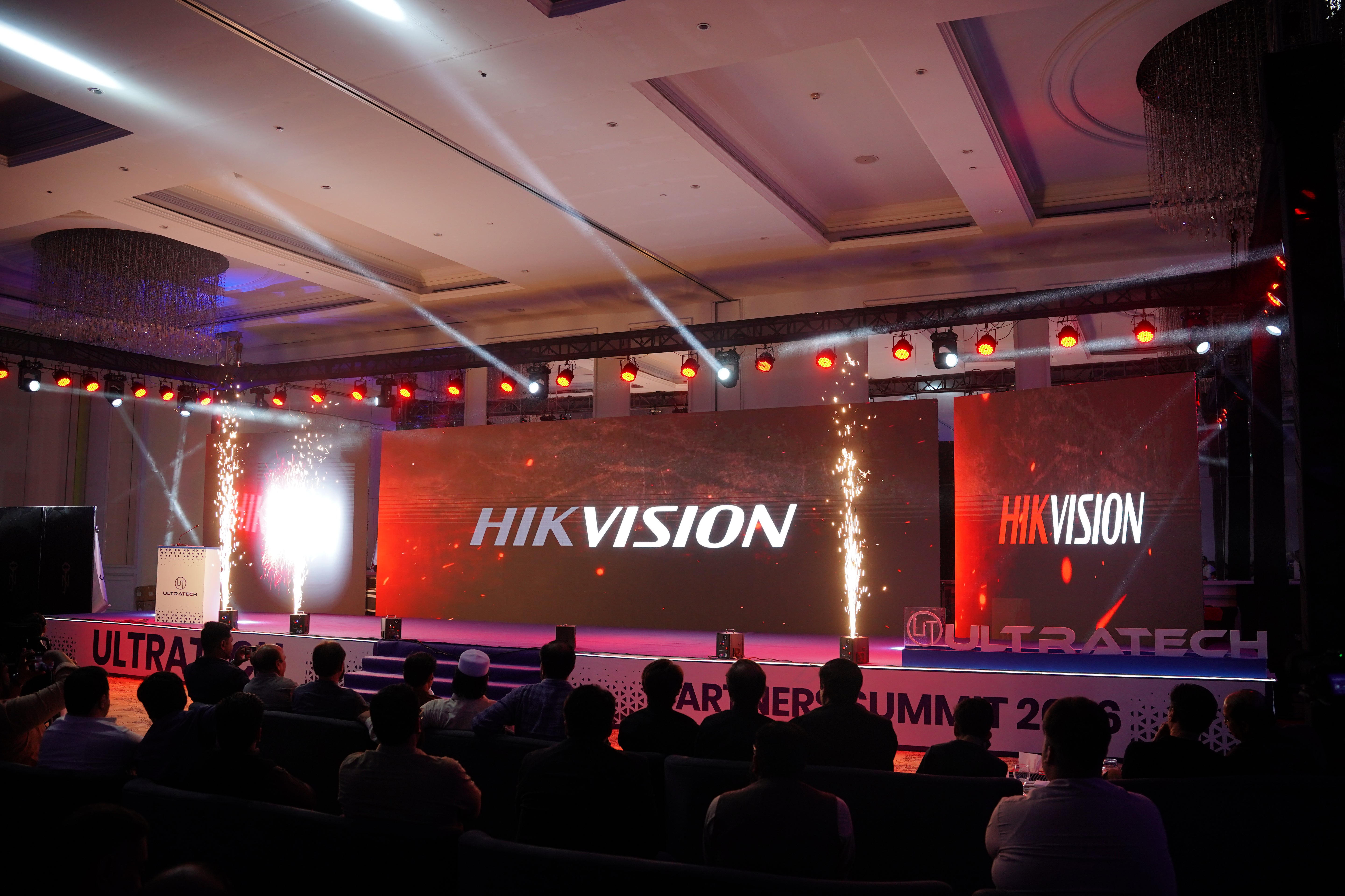 Event with Hikvision branding on a large screen, audience in foreground